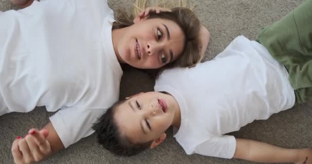 Amante mãe e filho se divertindo deitado no chão em casa — Vídeo de Stock