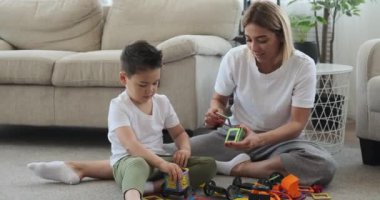 Anne ve oğul oyuncak araba monte ediyorlar. 