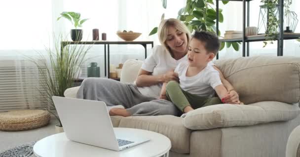 Мати і син насолоджуються переглядом фільму на ноутбуці — стокове відео