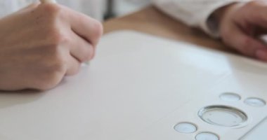 Ofiste grafik tableti kullanan bir kadın yeni proje tasarlıyor