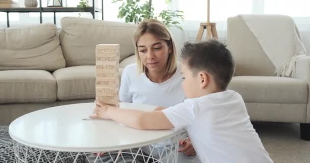 Мать с сыном играют в игру удаления деревянных блоков — стоковое видео