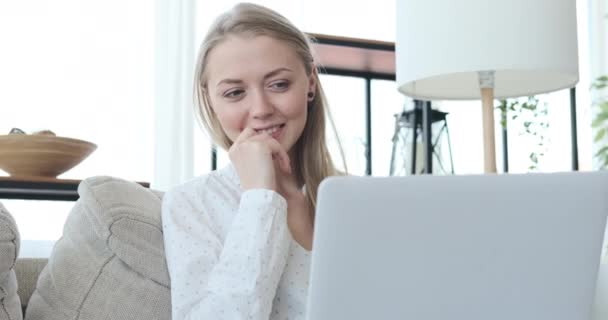 Gelukkig vrouw met behulp van laptop op bank thuis — Stockvideo