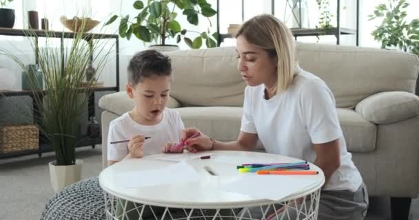 Mother with son drawing on paper at home — Stock Video