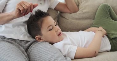 Anne ve oğlu evde film izliyor.