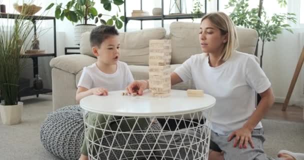 Mãe com filho jogando jogo de remoção de bloco de madeira — Vídeo de Stock