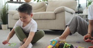 Neşeli anne ve oğul evde oyuncak topluyor.