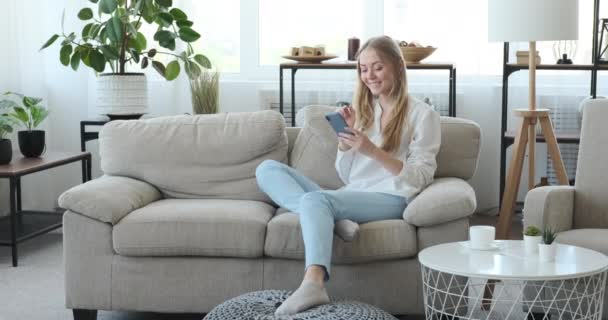 Femme réfléchie utilisant le téléphone mobile à la maison — Video