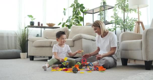 Madre e hijo construyendo coche de juguete en casa — Vídeos de Stock