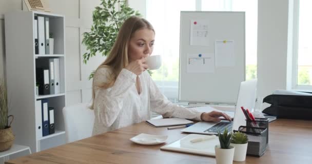 Geschäftsfrau trinkt Kaffee und arbeitet im Büro — Stockvideo