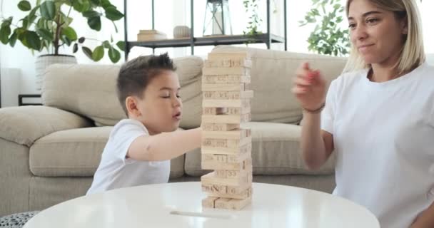 Mãe com filho jogando jogo de remoção de bloco de madeira — Vídeo de Stock