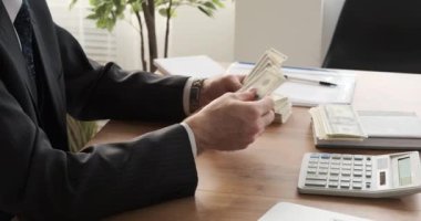 İşadamı ofiste para sayıyor.