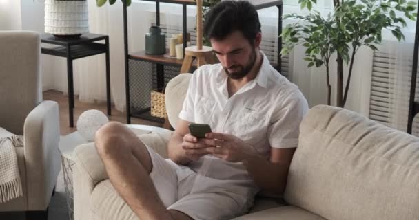 Άντρας που χρησιμοποιεί κινητό τηλέφωνο στο σπίτι — Αρχείο Βίντεο