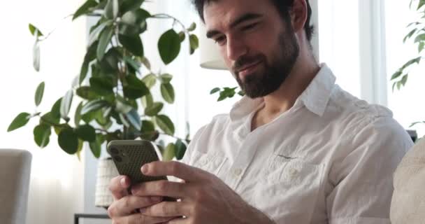 Hombre usando el teléfono móvil en casa — Vídeo de stock