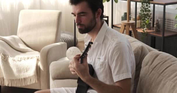 Hombre tocando la guitarra en casa — Vídeo de stock