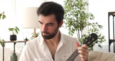 Evde gitar çalan adam.