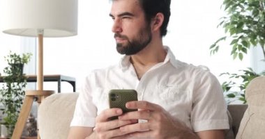 Evde cep telefonu kullanan adam.