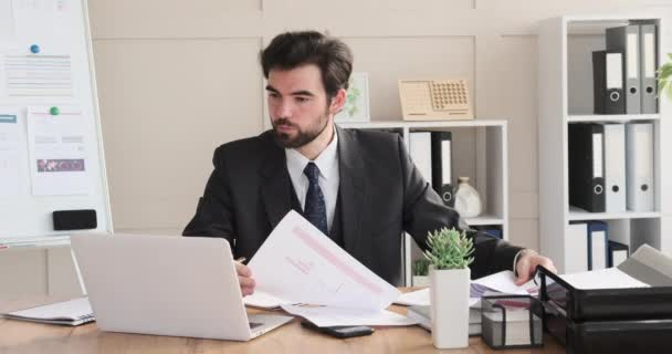 Homme d'affaires analysant le document et écrivant des notes au bureau — Video