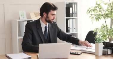 İşadamı, belgeyi analiz ediyor ve masa başında notlar yazıyor.