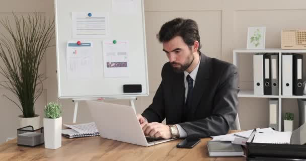 Nachdenklicher Geschäftsmann arbeitet im Büro am Laptop — Stockvideo