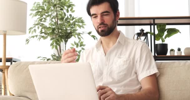 Чоловік відео чат використовує ноутбук вдома — стокове відео