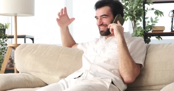 Happy man aan het praten op mobiele telefoon thuis — Stockvideo