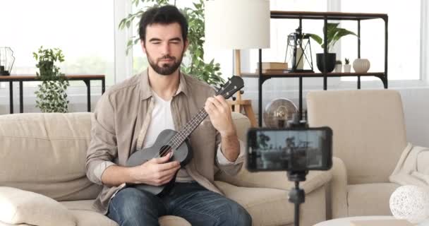 男演奏ギターとビデオのために彼のvlog — ストック動画