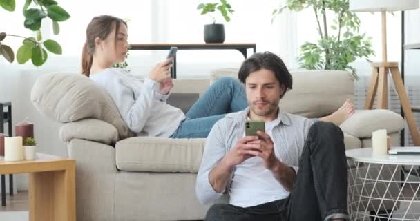 Pareja usando el teléfono móvil en casa — Vídeo de stock