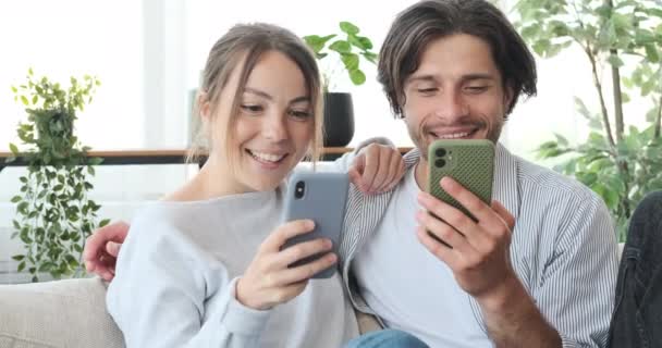 Casal usando telefone celular em casa — Vídeo de Stock