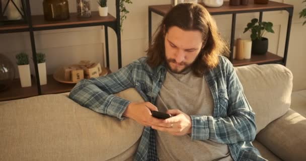 Человек, использующий мобильный телефон дома — стоковое видео