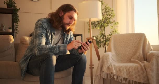 Muž textové zprávy na mobilním telefonu doma — Stock video