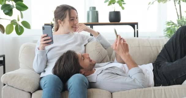 Pareja usando el teléfono móvil en casa — Vídeos de Stock