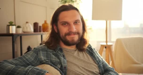 Happy man sitting on sofa at home — Stock Video