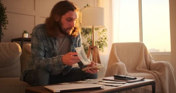 Чоловік ховає готівку, рахуючи вдома — стокове відео