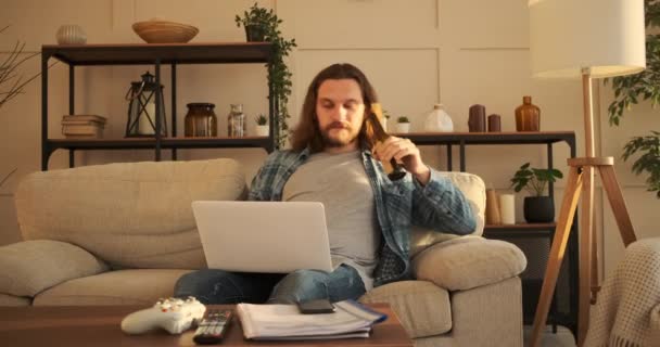 Muž používající notebook a pití piva doma — Stock video