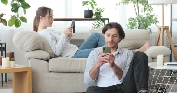 Par som använder mobiltelefon hemma — Stockvideo