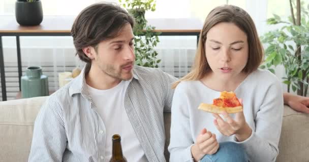 Пара насолоджується піцою і пивом під час розмови вдома — стокове відео