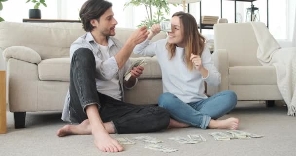 Игривая пара, анализирующая денежные купюры — стоковое видео