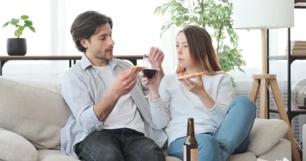 Пара їсть піцу і п'є червоне вино вдома — стокове відео