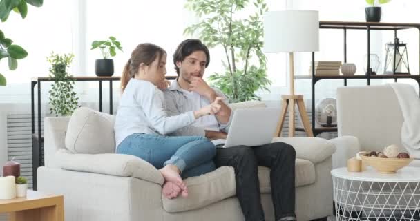 Casal de compras on-line usando laptop no sofá em casa — Vídeo de Stock