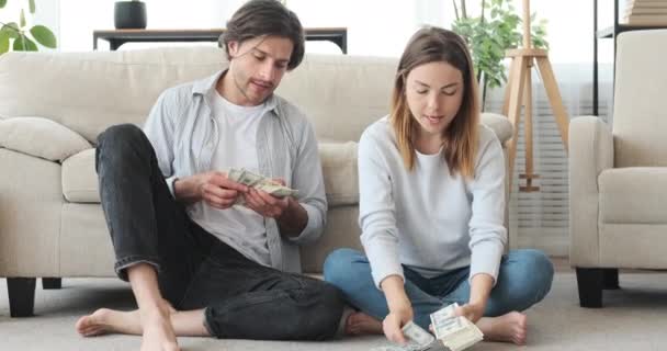 Пара подсчитывающих деньги банкнот и планирующих будущее — стоковое видео