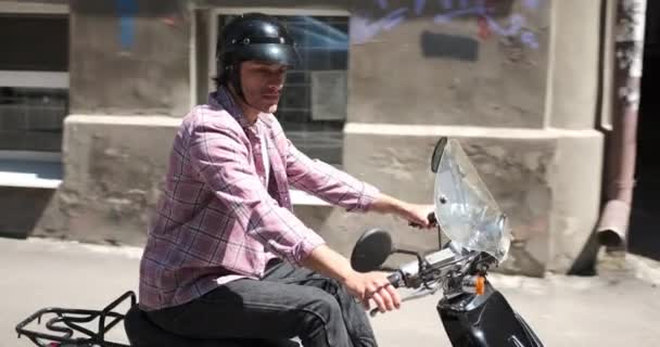 Чоловік їде скутер у місті — стокове відео
