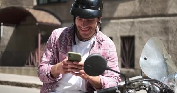 Homem sentado em scooter e tomando selfie usando telefone celular — Vídeo de Stock