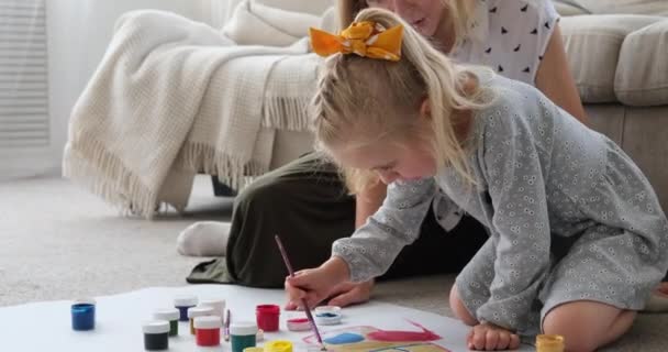 Mor med dotter målning tillsammans på pappersark hemma — Stockvideo