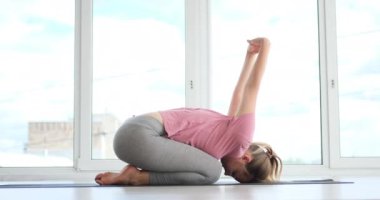 Kadın spor salonunda yoga yapıyor.