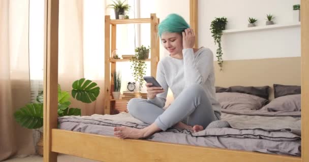 Boldog nő használja mobiltelefon az ágyon otthon — Stock videók