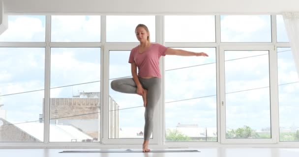 Kvinna som utövar yoga träd pose — Stockvideo