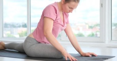 Kadın fitness stüdyosunda yoga pozu alıştırması yapıyor.