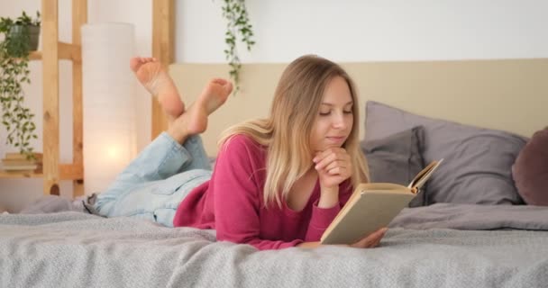 Kvinna läser en bok hemma — Stockvideo