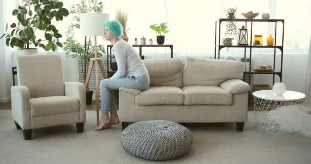 Keder sig kvinde falder tilbage på sofaen derhjemme – Stock-video