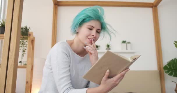 Gelukkig vrouw het lezen van een boek in slaapkamer — Stockvideo